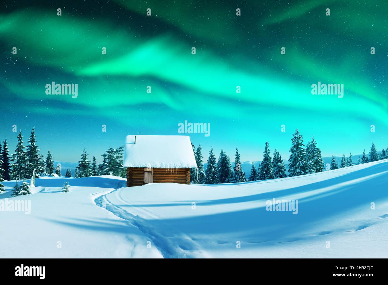 Fantastico paesaggio invernale con casa in legno con luce nella finestra in montagne innevate e northen luce nel cielo notturno. Vacanze di Natale e le vacanze invernali concept Foto Stock