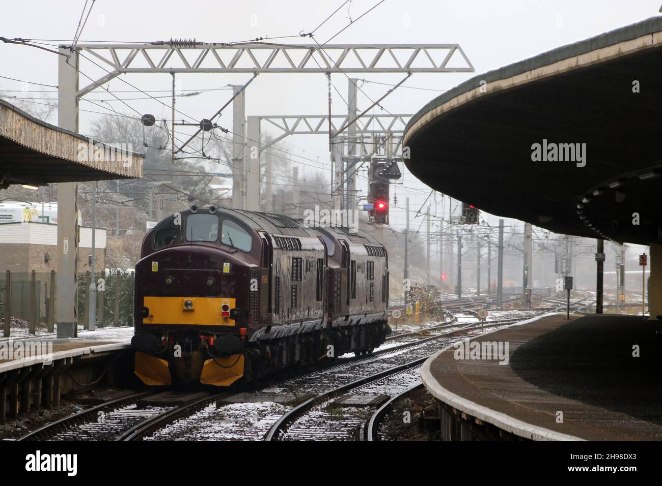 Due locomotive diesel-elettriche di classe 37 nella West Coast Railway livrea maroon passano attraverso la stazione ferroviaria di Carnforth in una prova, il 29 novembre 2021. Foto Stock