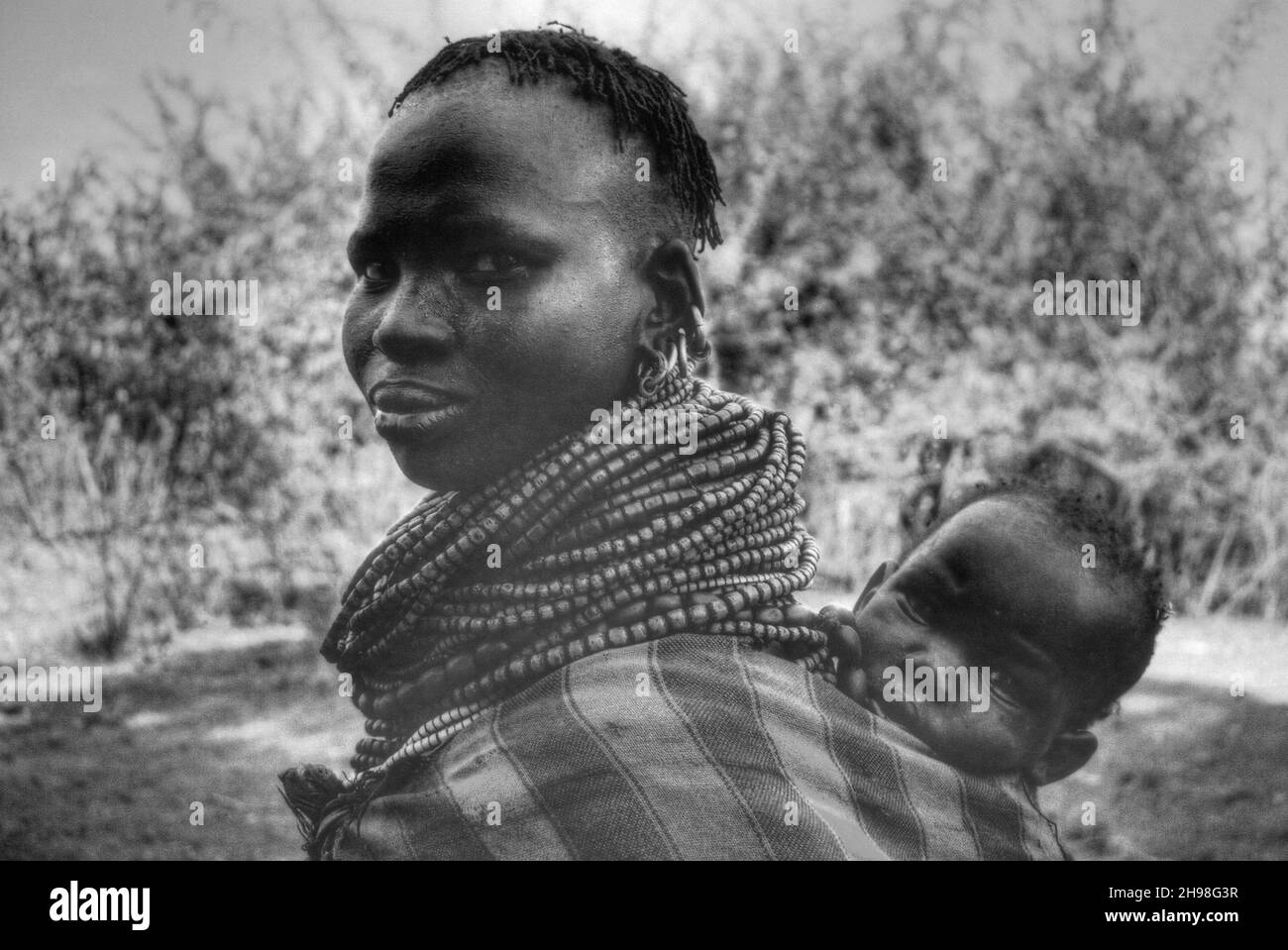 Nyangatom Tribe (a.k.a. Dongiro, Donyiro e pejorativamente come Bumé) madre che porta il bambino Foto Stock