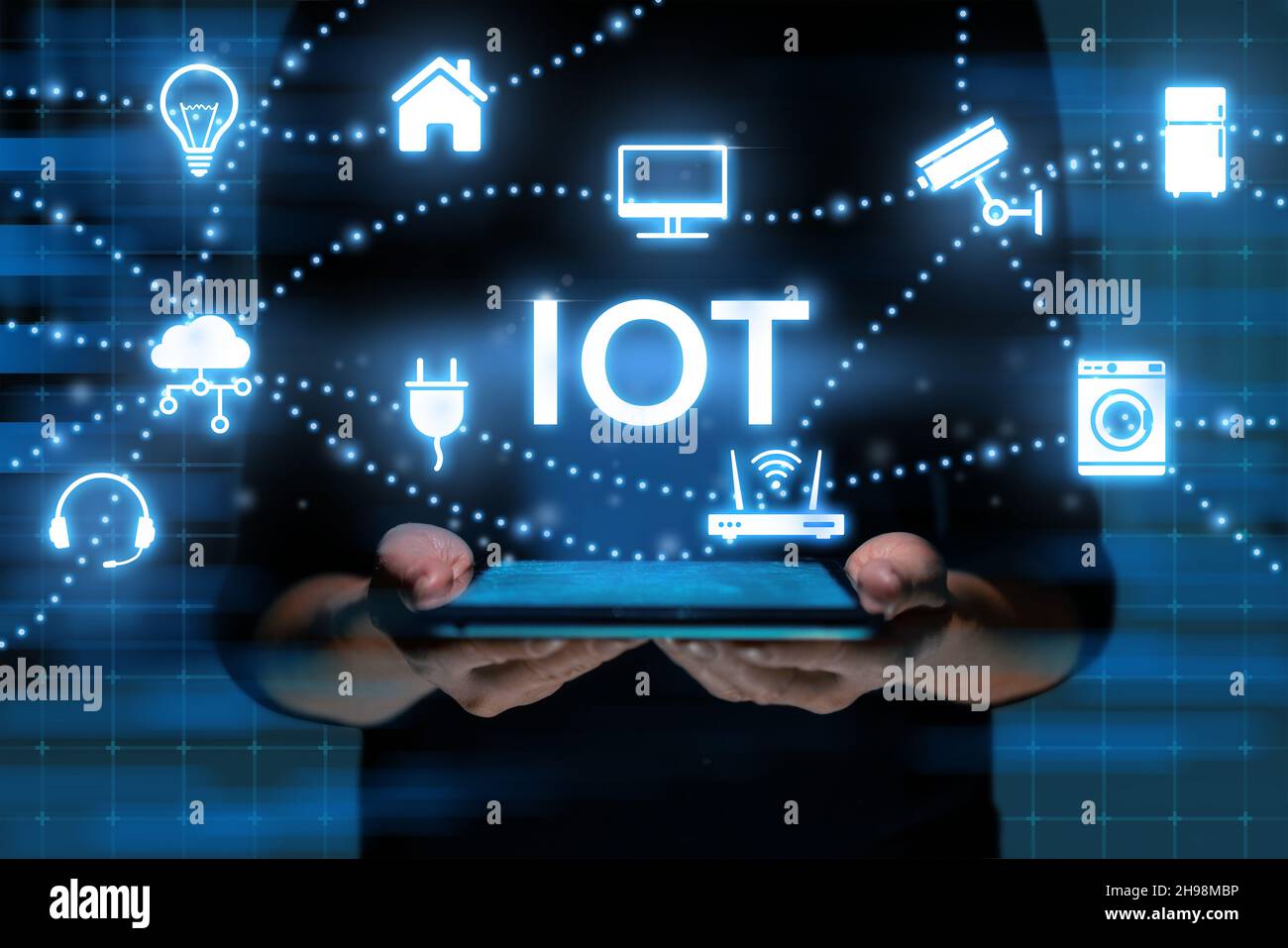 Concetto IoT o Internet delle cose. La persona controlla l'apparecchiatura e la sicurezza attraverso un tablet nelle sue mani. Foto Stock