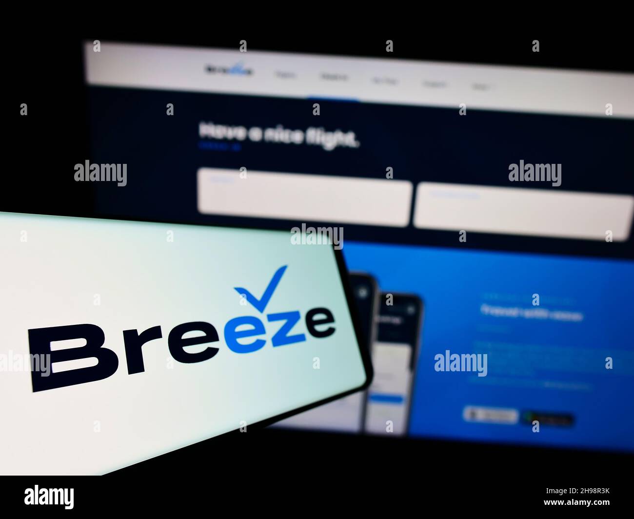 Telefono cellulare con logo della compagnia aerea statunitense Breeze Airways sullo schermo di fronte al sito web aziendale. Messa a fuoco al centro-sinistra del display del telefono. Foto Stock