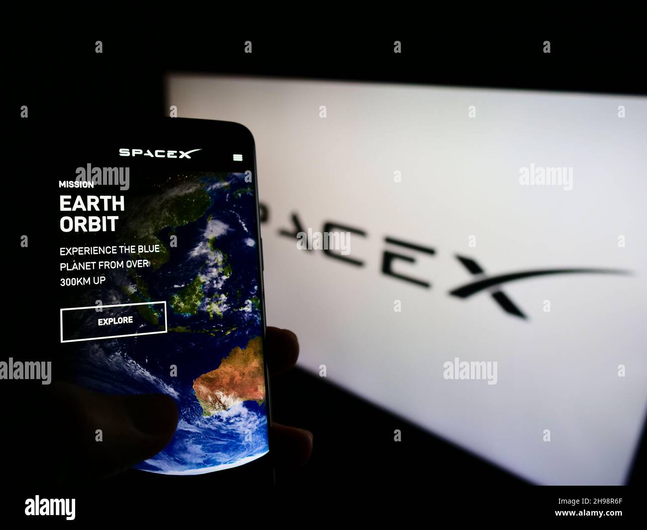 Persona che tiene lo smartphone con il sito Web dell'azienda Space Exploration Technologies (SpaceX) sullo schermo con il logo. Concentrarsi sul centro del display del telefono. Foto Stock