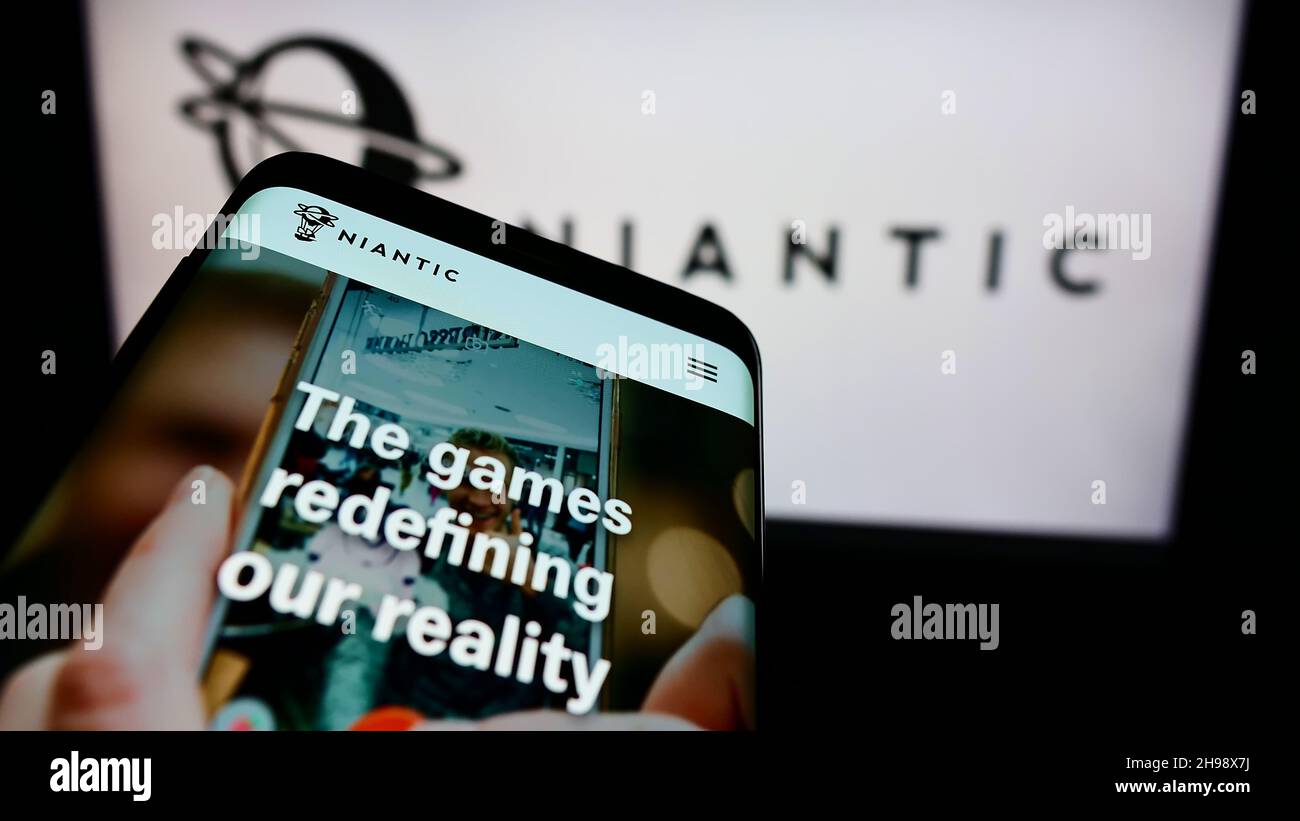 Telefono cellulare con pagina web della società statunitense di software di gioco Niantic Inc. Sullo schermo di fronte al logo aziendale. Mettere a fuoco sulla parte superiore sinistra del display del telefono. Foto Stock