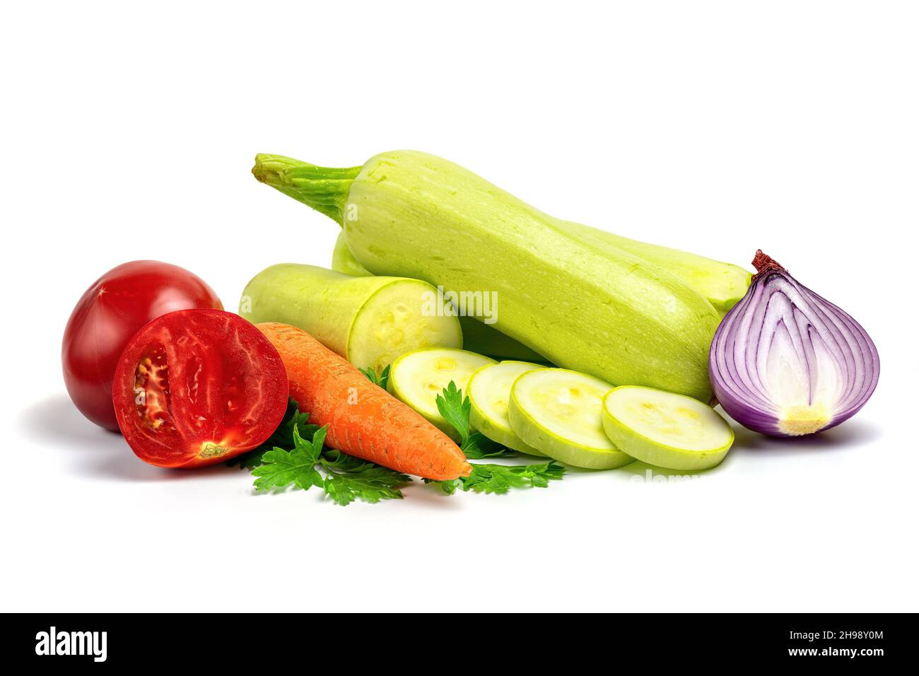 Verdure fresche per la cottura di stufato vegetale isolato su sfondo bianco. Ingredienti crudi per insalata vegetale: Zucchine o midollo, cipolla, pomodoro, carr Foto Stock