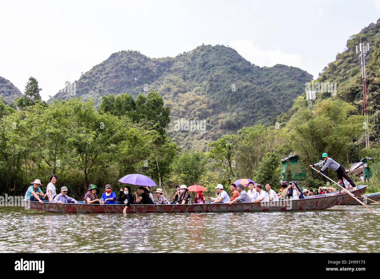 Turistico a pagoda di profumo viaggio rendendo il loro modo di famose grotte e templi in barche lungo Yen Vy fiume nel Vietnam del Nord Foto Stock