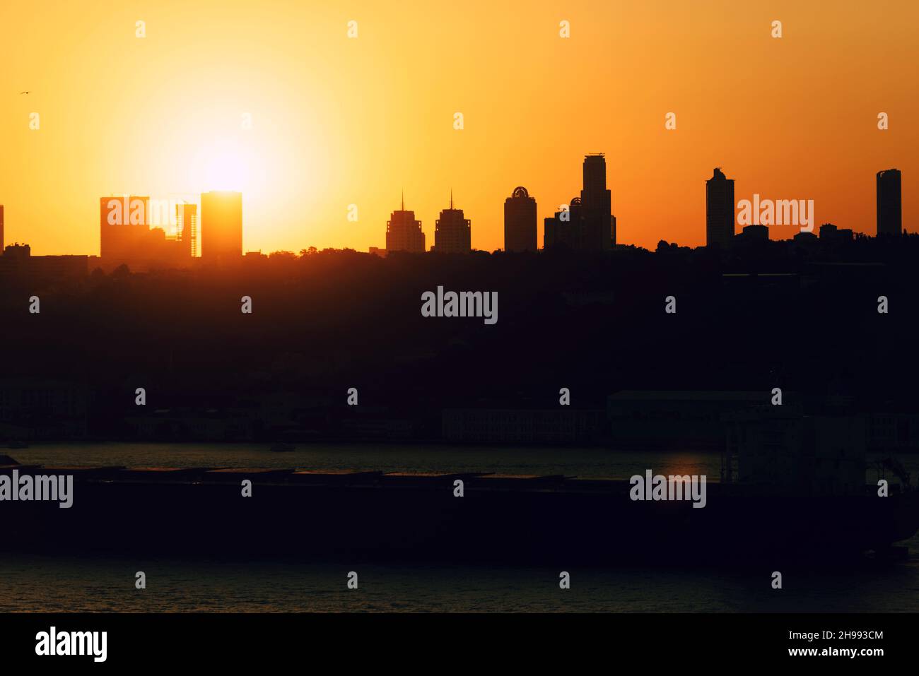 Tramonto dietro gli edifici di istanbul. Creazione di silhouette. La nave che attraversa il Bosforo. Foto Stock