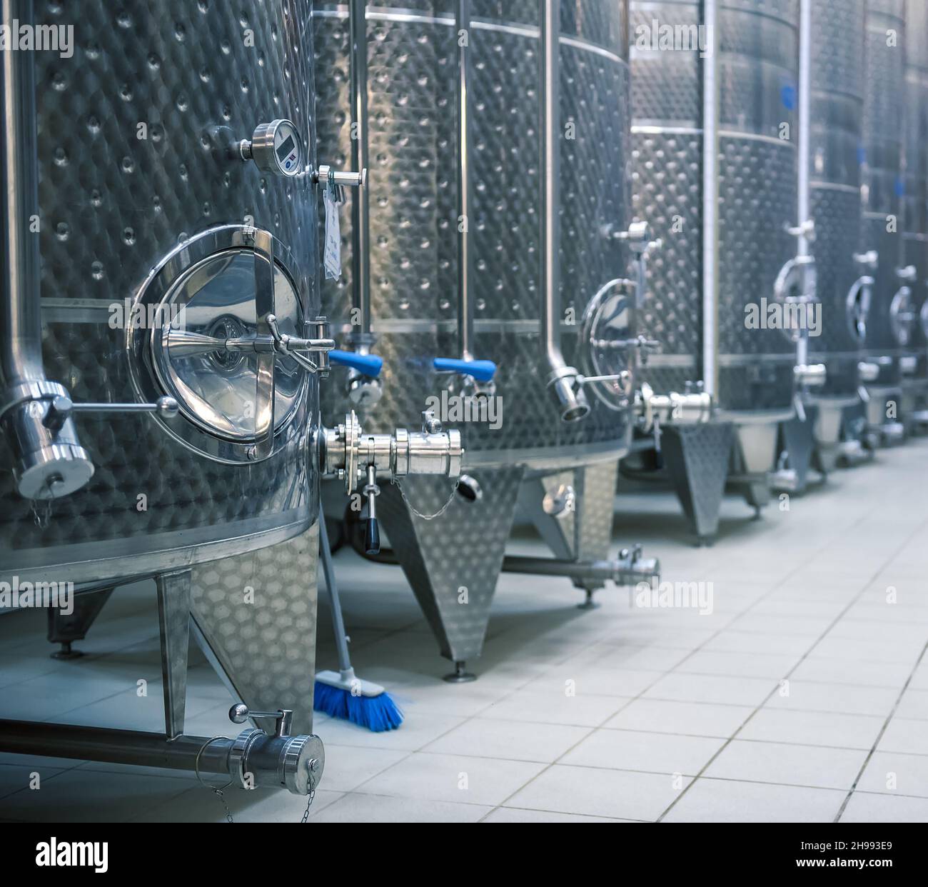 Vasche in acciaio inox per la fermentazione delle uve. Interno cantina, fuoco selettivo Foto Stock