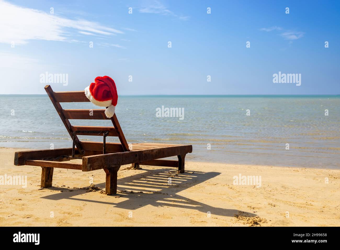 Cappello Babbo Natale sulla sedia lounge sulla spiaggia di mare Foto Stock