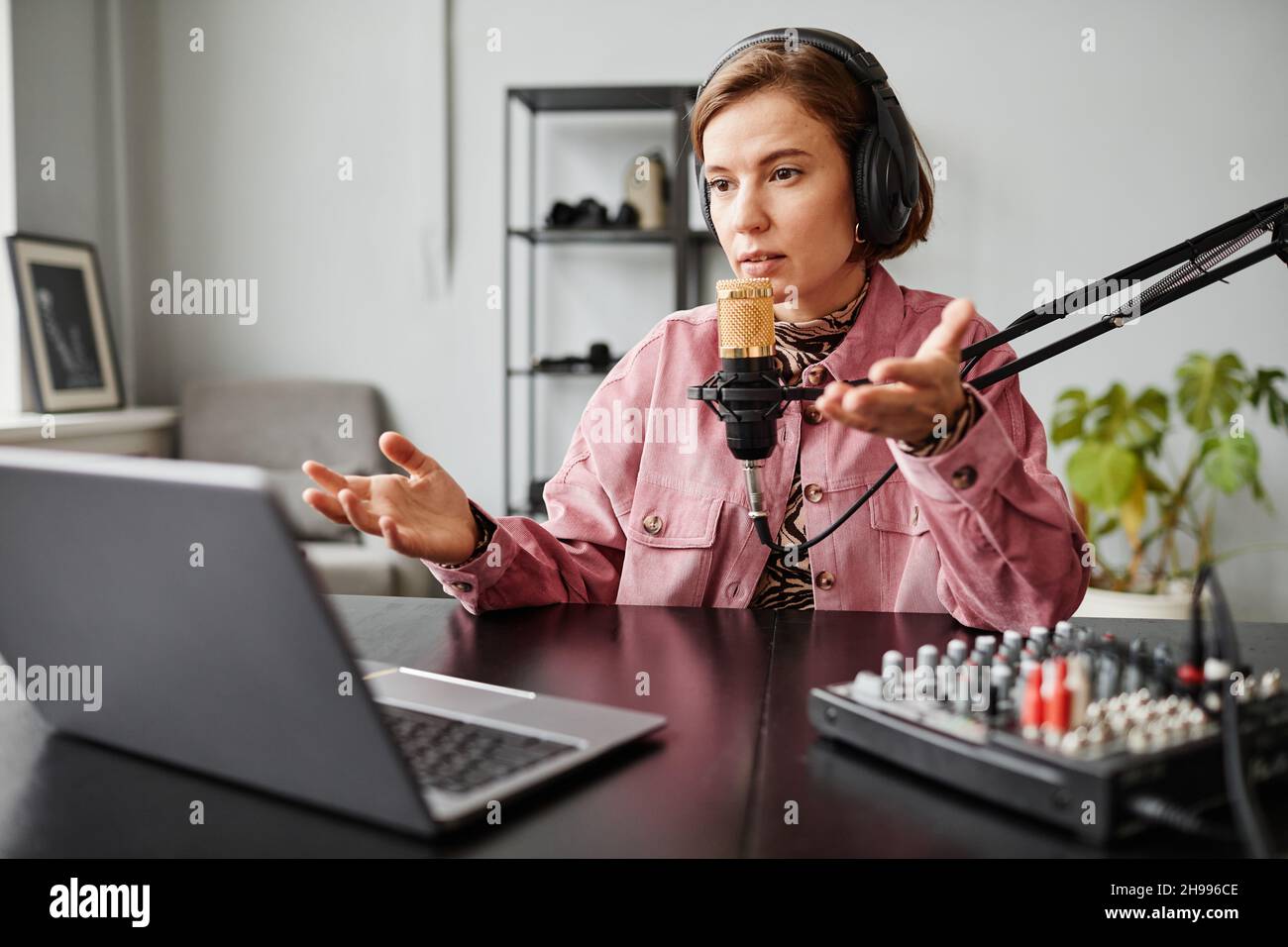 Ritratto del creatore di contenuti femminile parlare al microfono durante la registrazione podcast in studio, spazio di copia Foto Stock