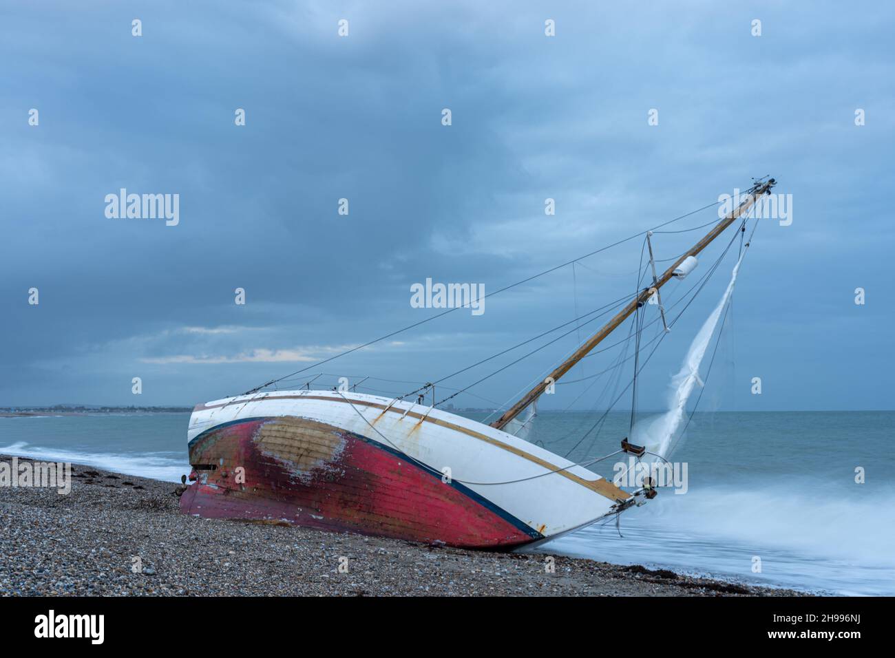 Abbandonata e naufragata barca a vela aground sulla spiaggia a Chiesa Norton tra Pagham e Selsey vicino Chichester nel Sussex occidentale. Foto Stock