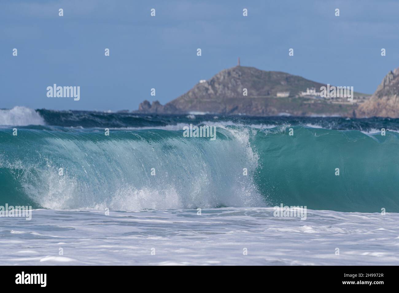 Surf verde smeraldo sulla spiaggia di Sennen Cove nella Cornovaglia occidentale con Cape Cornwall in lontananza. Foto Stock