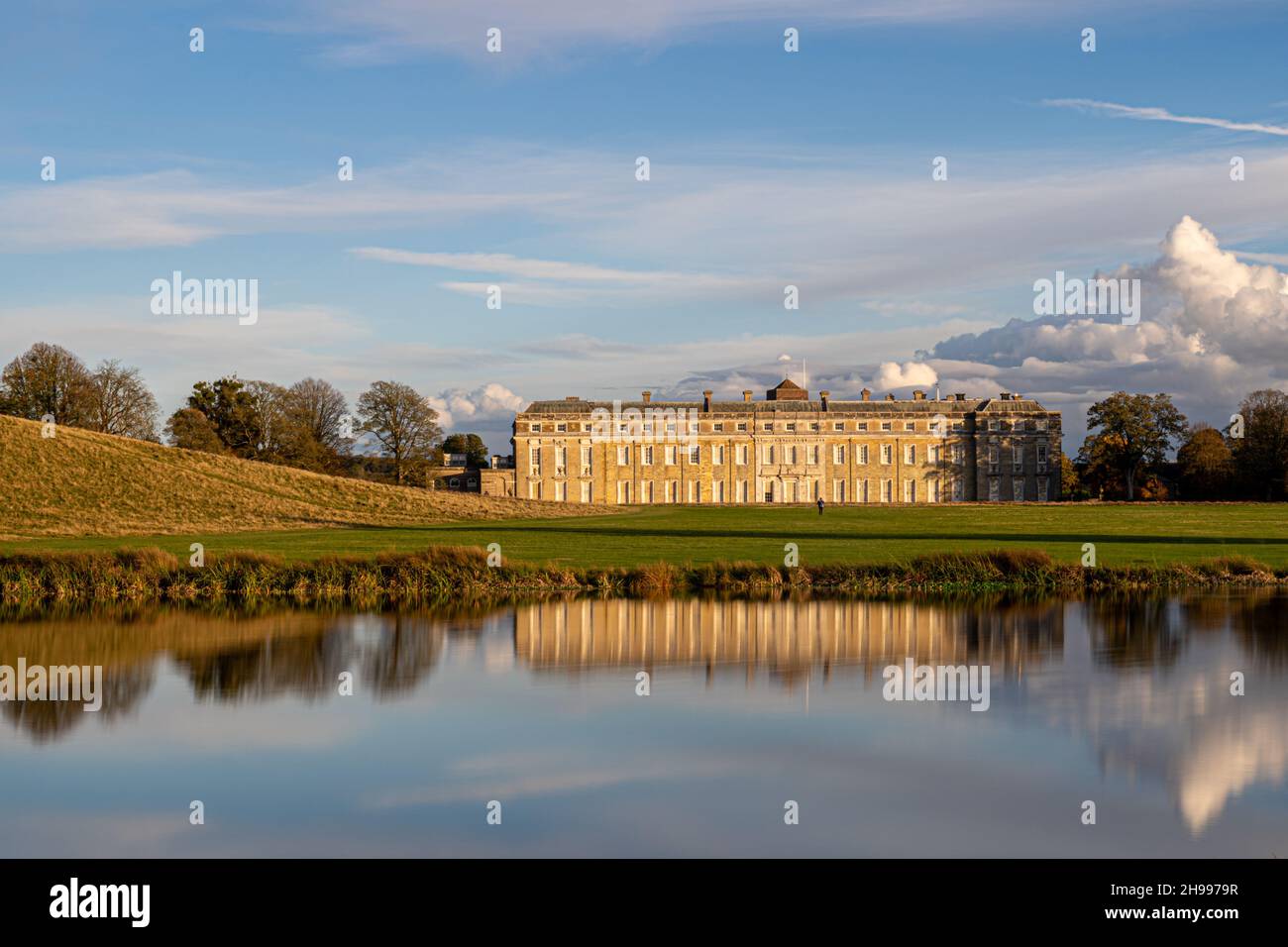 Petworth Park and House si riflette nella luce del tardo autunno con un cielo mozzafiato sopra Foto Stock