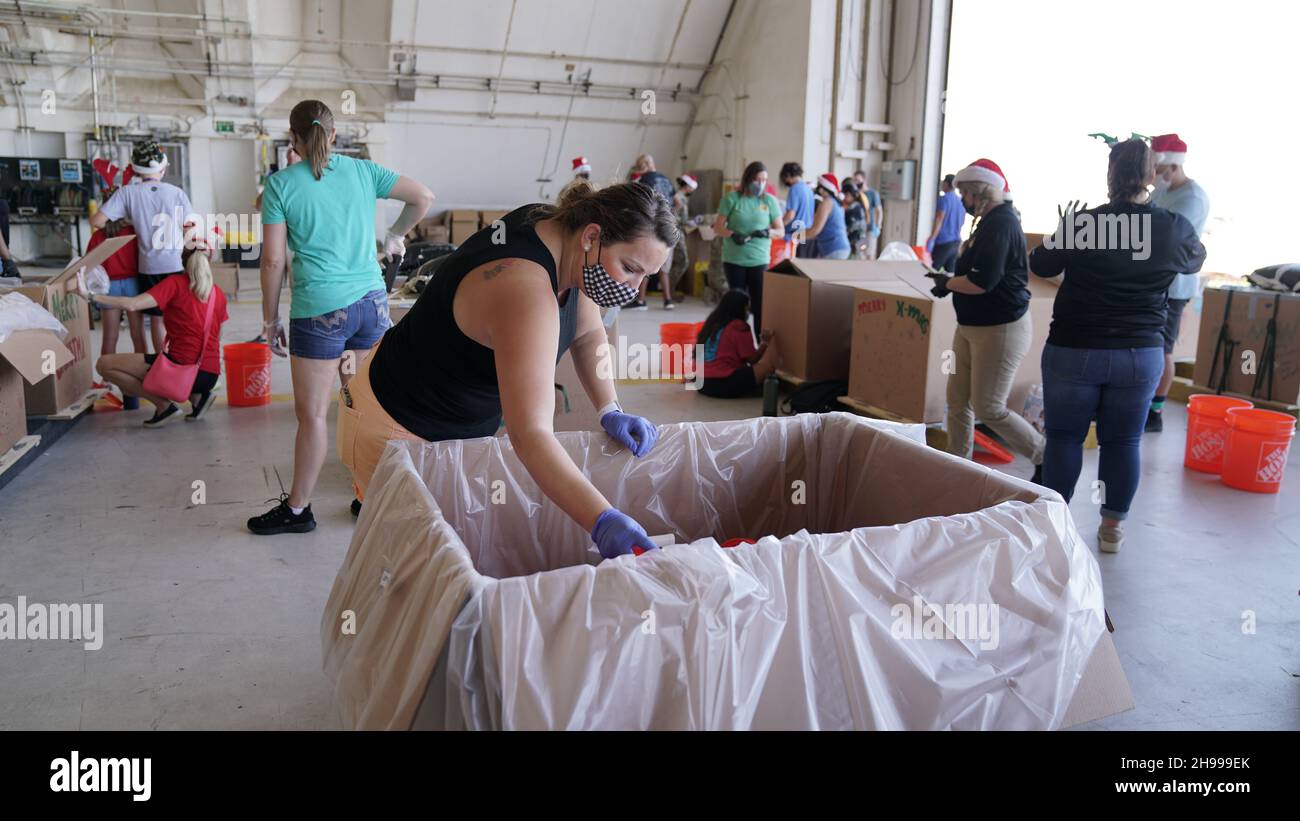 Yigo, Stati Uniti. 4 dicembre 2021. I volontari imballano le merci donate e decorano i pacchetti airdrop con i messaggi a sostegno della 70a operazione annuale di Natale drop alla base militare Andersen 4 dicembre 2021 a Yigo, Guam. Ogni dicembre, airdrop donerà cibo, forniture, materiale didattico e strumenti a 55 nazioni insulari in tutto il Pacifico sudorientale. Credito: 1 lt. Jade Watkins/US Airforce Photo/Alamy Live News Foto Stock