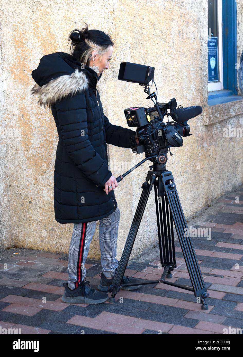 Un giovane regista gestisce una videocamera Canon mentre realizza un documentario presso la storica stazione ferroviaria Lamy di Lamy, New Mexico. Foto Stock