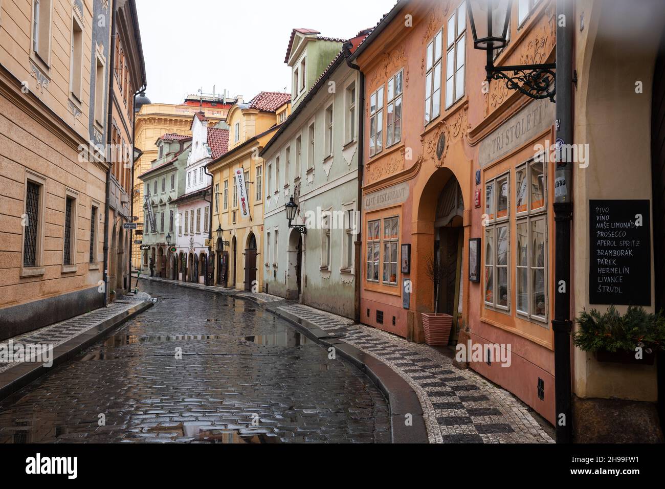 Praga, 11 marzo 2020: Strada stretta con caffè e ristoranti nel centro storico di Praga vuoto sotto la pioggia Foto Stock