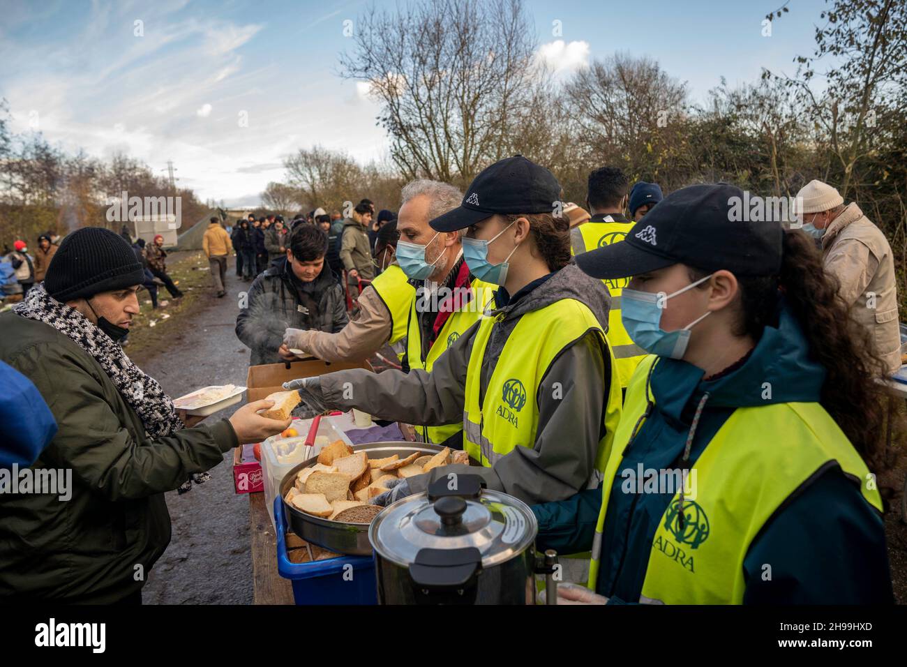 Dunkerque, Francia. 05 dicembre 2021. I volontari dell'ADRA (Agenzia Avventista per lo sviluppo e il soccorso) hanno visto servire cibo ai migranti in un campo migrante improvvisato. Ci sono stimati circa 800 migranti/rifugiati che attualmente soggiornano nell'area di Dunkerque nella Francia settentrionale. La maggior parte di loro sono in attesa delle loro opportunità di raggiungere il Regno Unito sia da gommoni gommoni o nascondersi in camion. Credit: SOPA Images Limited/Alamy Live News Foto Stock