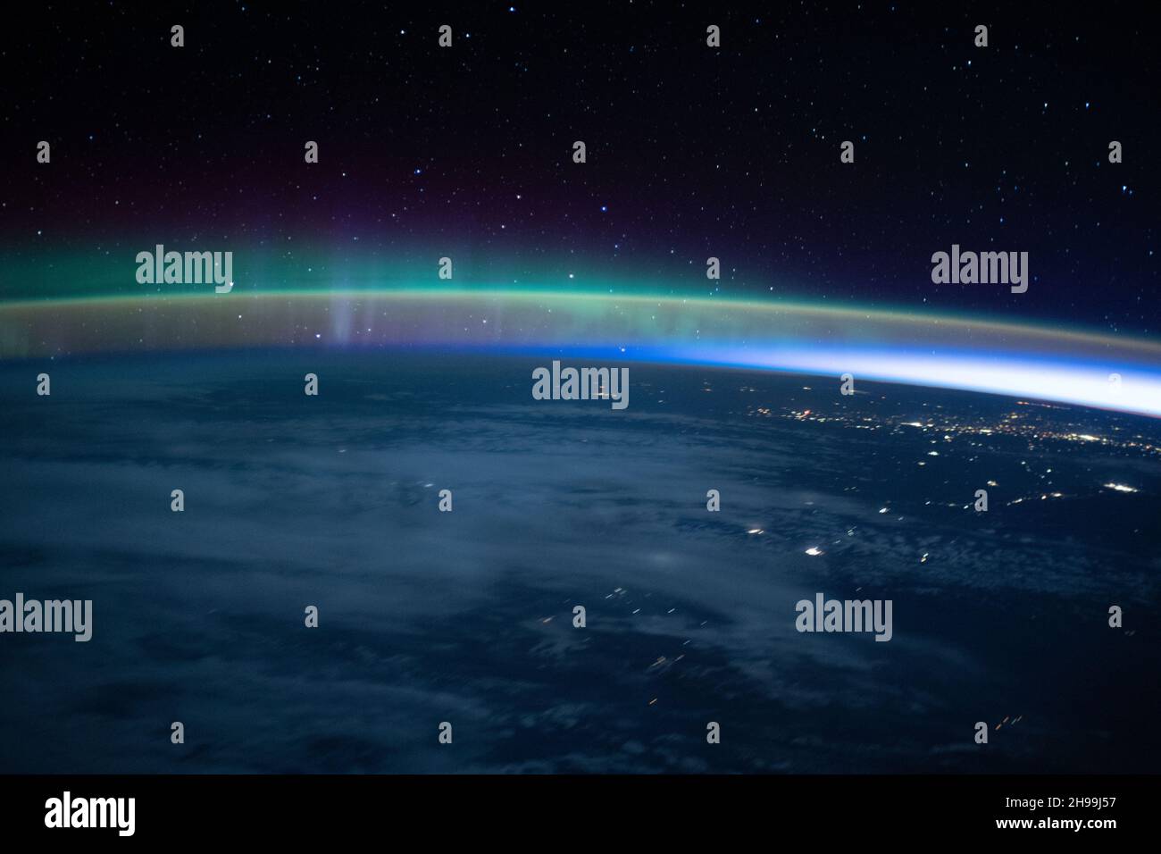 Aurora si intersecò con il bagliore della Terra mentre la Stazione spaziale Internazionale volò in un'alba orbitale a 264 miglia sopra l'Oceano Pacifico prima di attraversare il Canada. Foto Stock