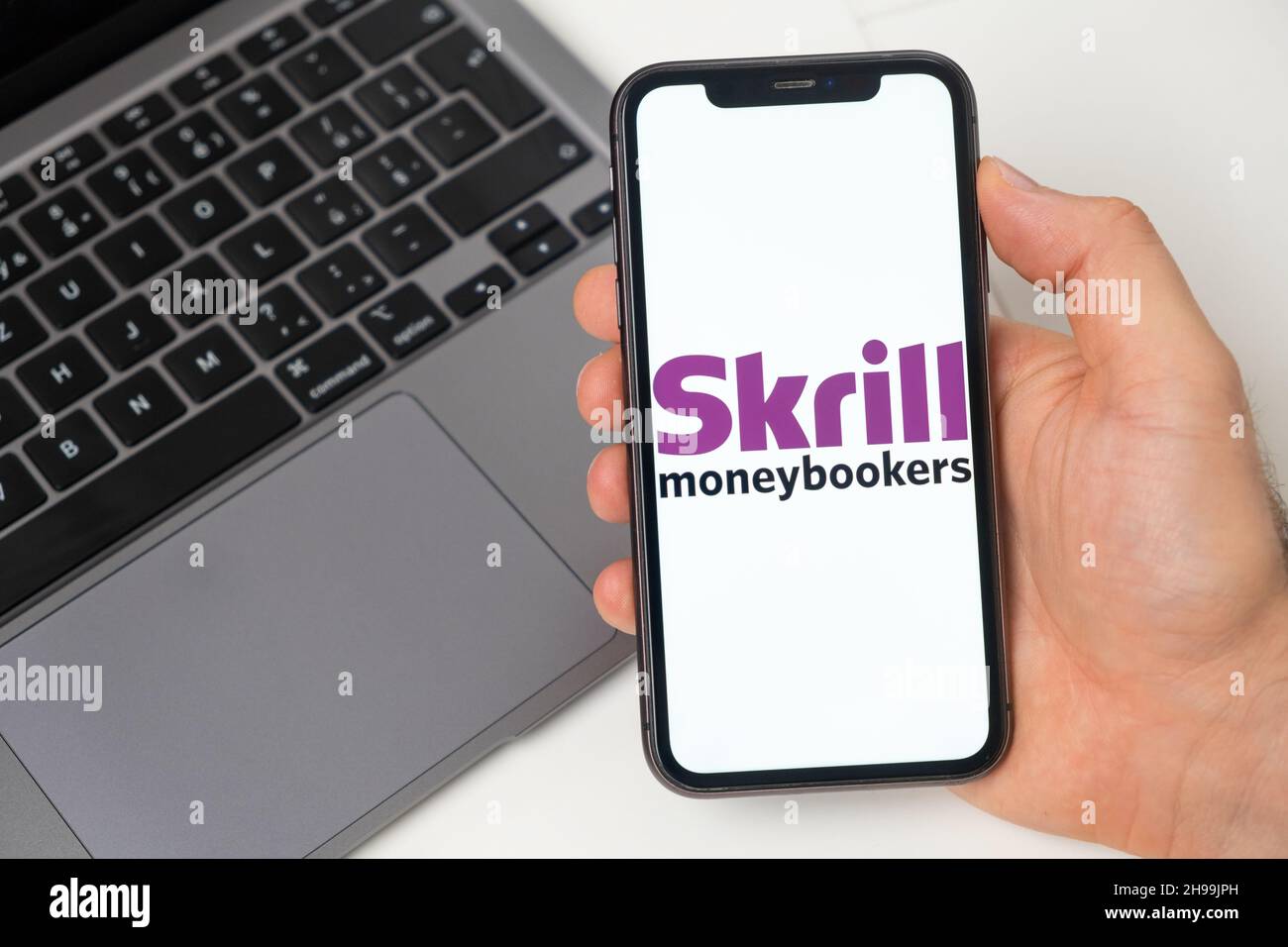 Il sistema di pagamento Skrill consente di effettuare trasferimenti di denaro. Acquisti online con smartphone e notebook. Un modo veloce, sicuro e sociale per pagare e ricevere denaro. Sfondo bianco. Novembre 2021, San Francisco, USA Foto Stock