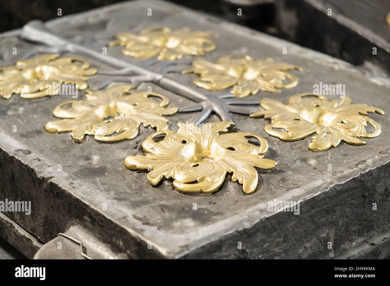 Fiori dorati eleganti e rami grigi modellati in calco di alta precisione nella tradizionale officina di produzione vista ravvicinata Foto Stock