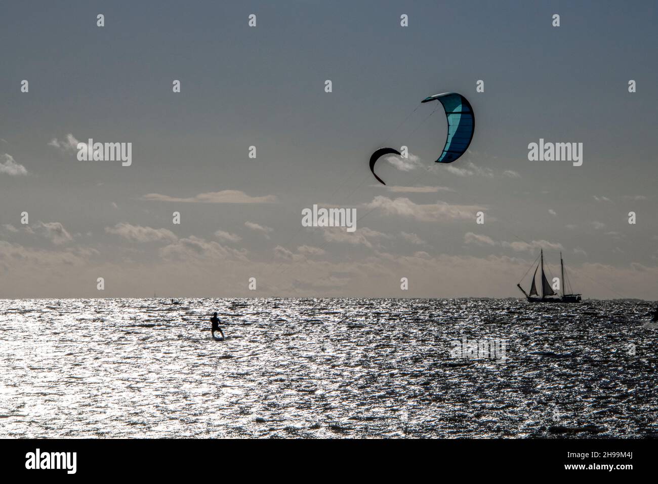 Alcune persone amano praticare sport estremi come il kitesurf al mare Foto Stock