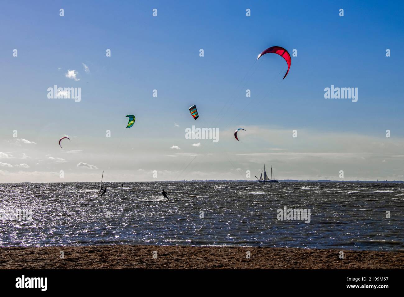 Alcune persone amano praticare sport estremi come il kitesurf al mare Foto Stock