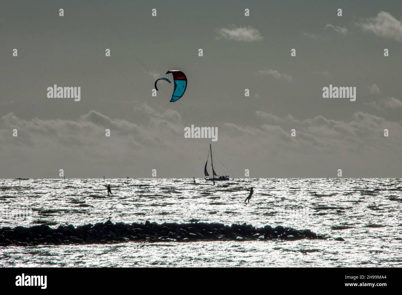 Alcune persone amano praticare sport estremi come il kitesurf al mare Foto Stock
