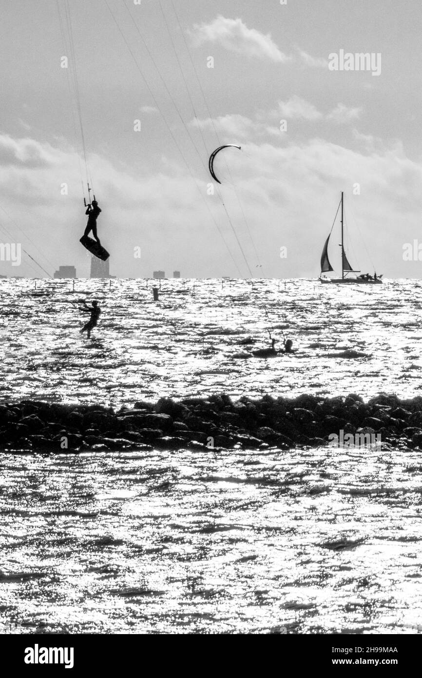 Alcune persone amano praticare sport estremi come il kitesurf al mare Foto Stock