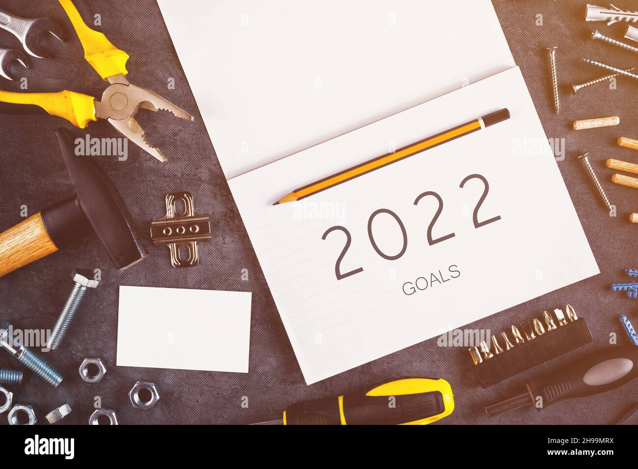 2022 obiettivi, assortiti fai da te utensili fai-da-te e notebook su scrivania in officina, progettando progetti di miglioramento della casa nel nuovo anno Foto Stock