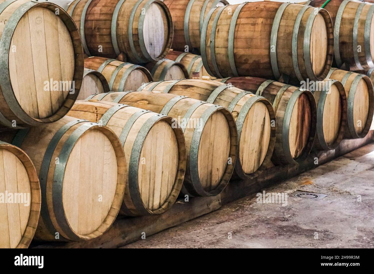 file di botti di vino in legno in un deposito di cantina Foto Stock