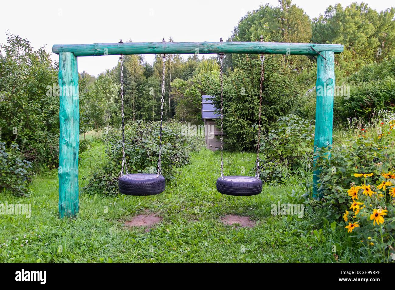 Ala auto made in pneumatico e catene in metallo nel giardino estivo. Foto Stock