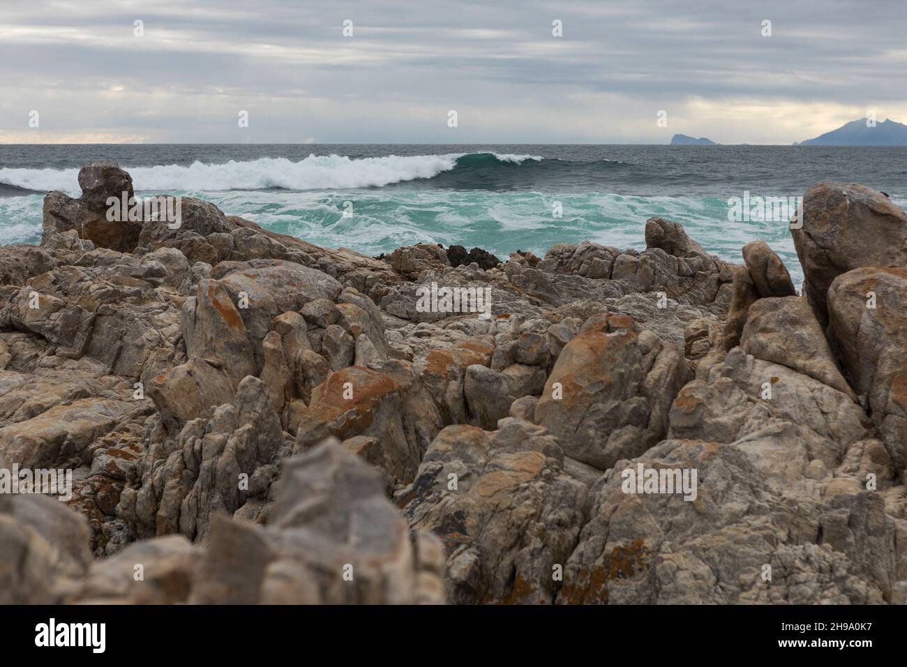 Formazioni rocciose e oceano, De Kelders, Capo Occidentale, Sudafrica. Foto Stock