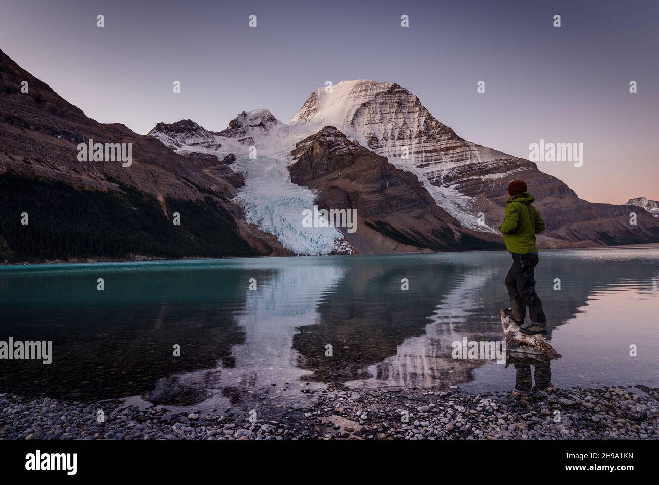 Uomo che guarda il Monte Robson sopra il lago di Berg all'alba. Foto Stock