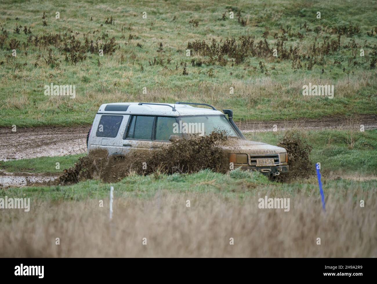 Veicolo fuoristrada Land Rover Discovery II 2 4x4 che attraversa terreni fangosi e bagnati, Salisbury Plain Wilts UK. Foto Stock