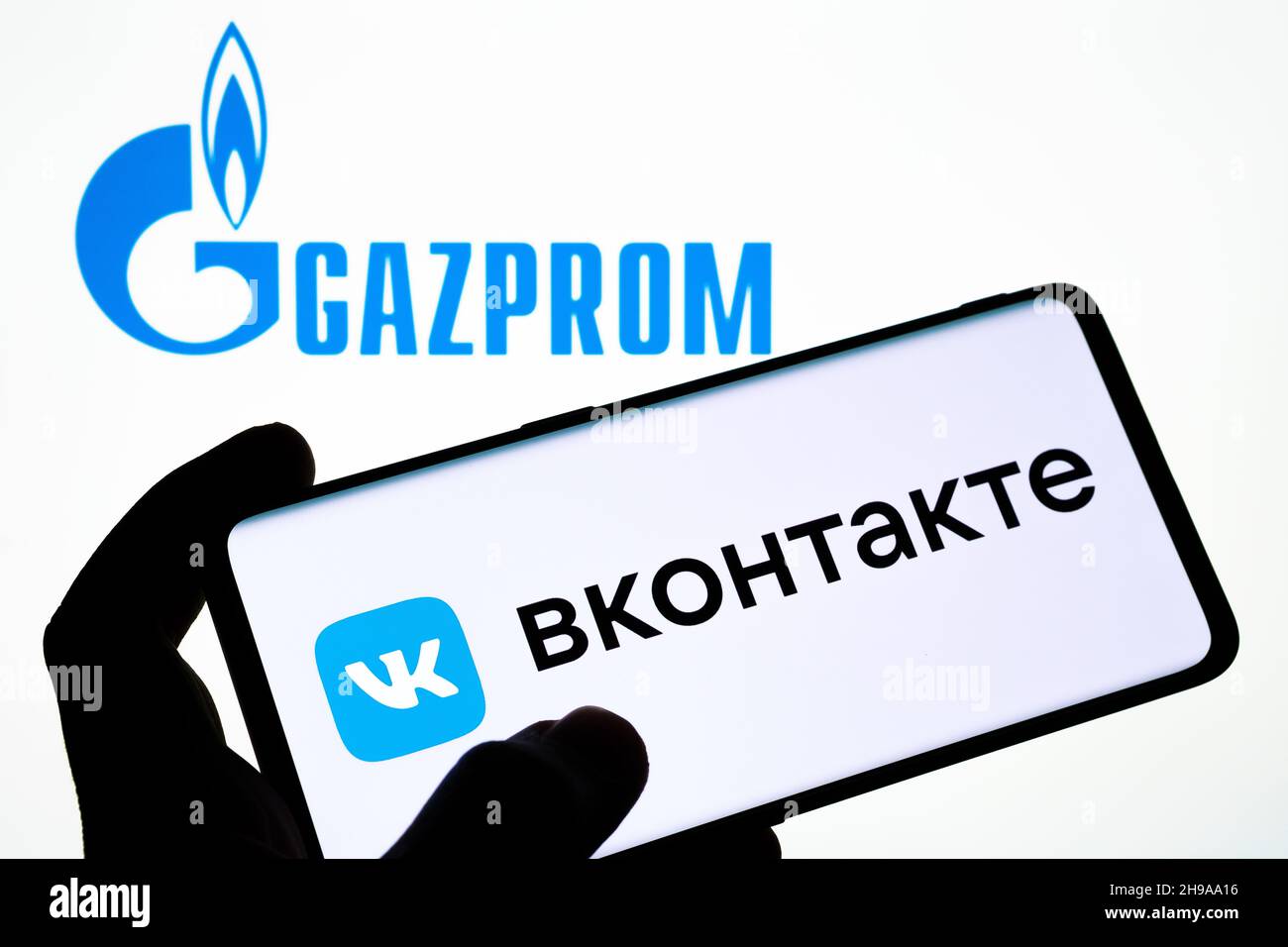 Logo VK VKONTAKTE apposto sullo smartphone e logo GAZPROM sul laptop sfocato. Parola in russo tradotte come 'VKONTAKTE'. Concetto. Stafford, Regno Unito Foto Stock
