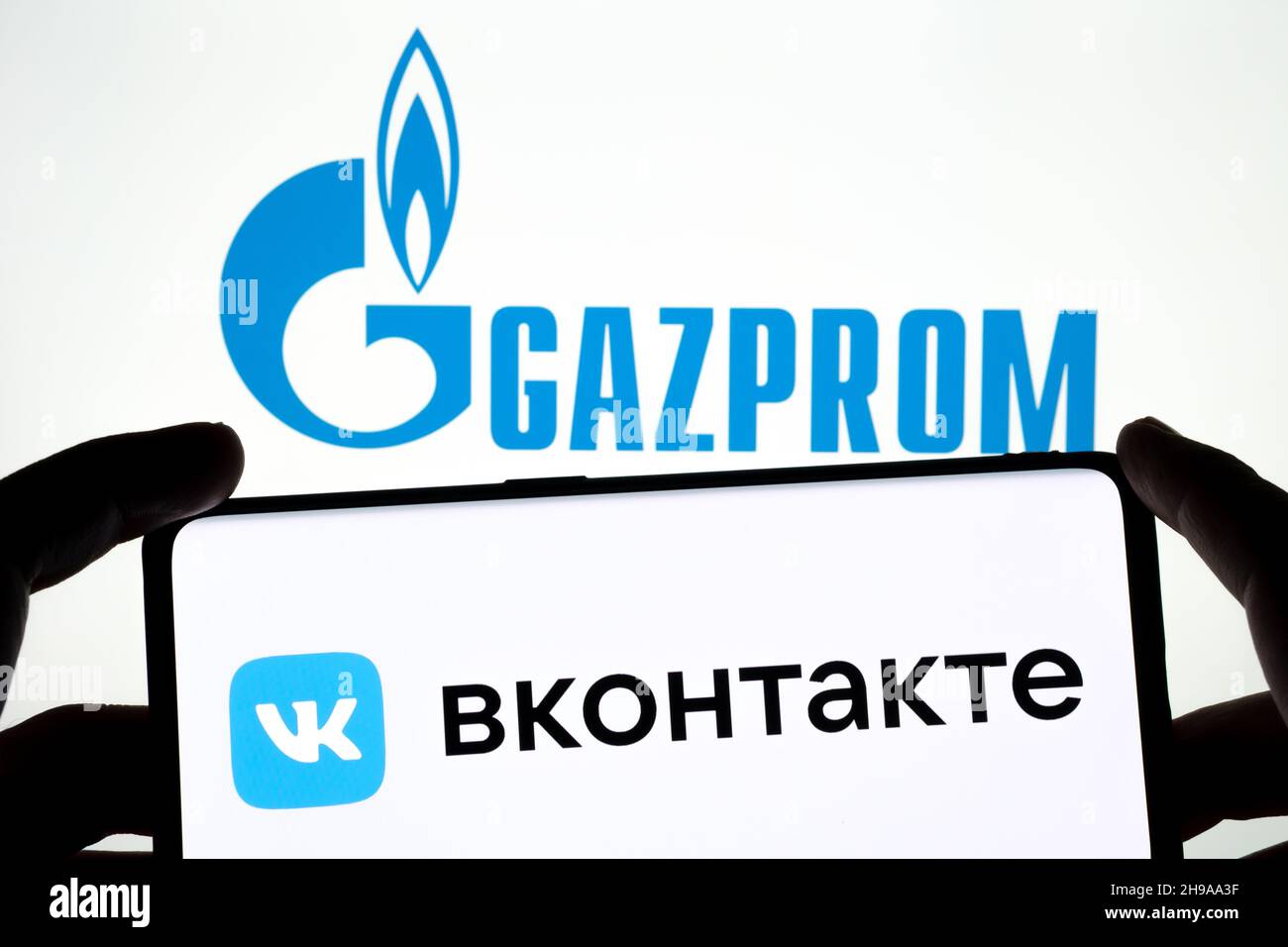 Logo VK VKONTAKTE apposto sullo smartphone e logo GAZPROM sul laptop sfocato. Parola in russo tradotte come 'VKONTAKTE'. Concetto. Stafford, Regno Unito Foto Stock