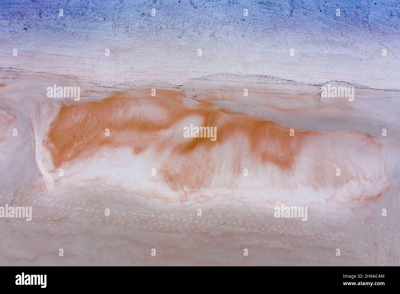 Al mattino presto bella cima giù antenna di spiaggia sabbia modello che assomiglia ad una volpe dormiente e una linea di impronte di piedi che attraversano la sabbia Foto Stock