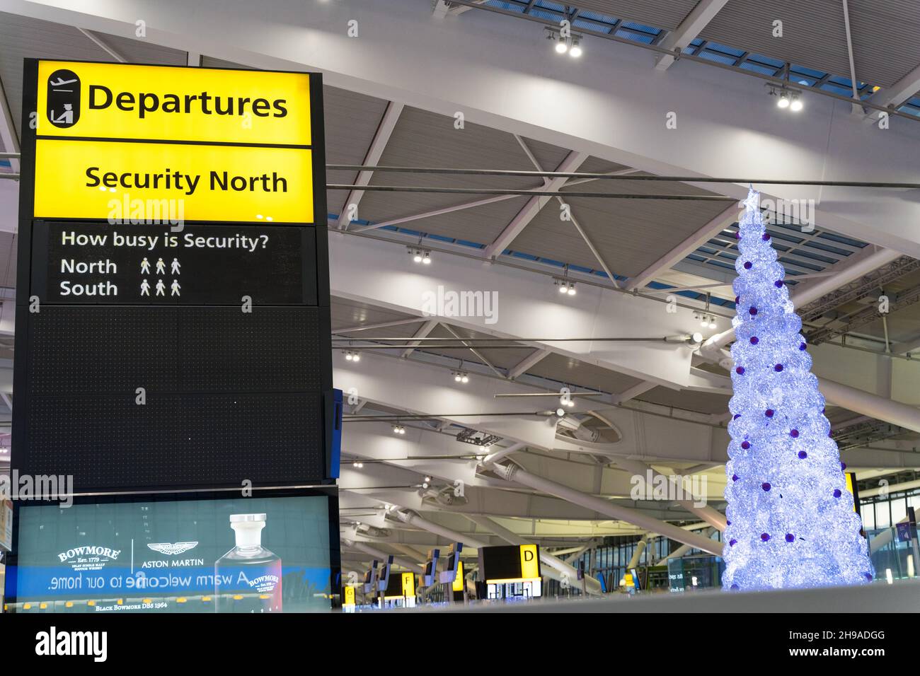 Voli sale di partenza decorate con alberi di Natale presso i terminal dell'aeroporto di Londra Heathrow in mezzo alla variante omicron sparso nei viaggi invernali. Inghilterra Regno Unito Foto Stock