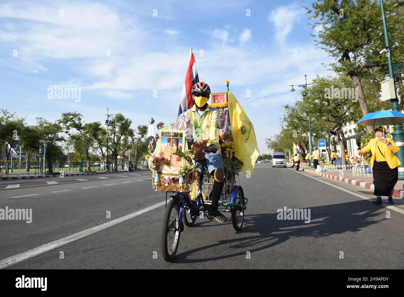 Bangkok, Tailandia. 5 dicembre 2021. Persone che sono fedeli a indossare camicie gialle e che mostrano le immagini dei monarchi thailandesi in attesa della processione reale del re thailandese su Ratchadamnoen Road, mentre la processione reale dell'auto passa al Grand Palace in occasione del compleanno di sua Maestà il tardo re Bhumibol Adulyadej il Grande, la Giornata Nazionale Tailandese e la Giornata del Padre della Thailandia. (Credit Image: © Teera Noisakran/Pacific Press via ZUMA Press Wire) Foto Stock