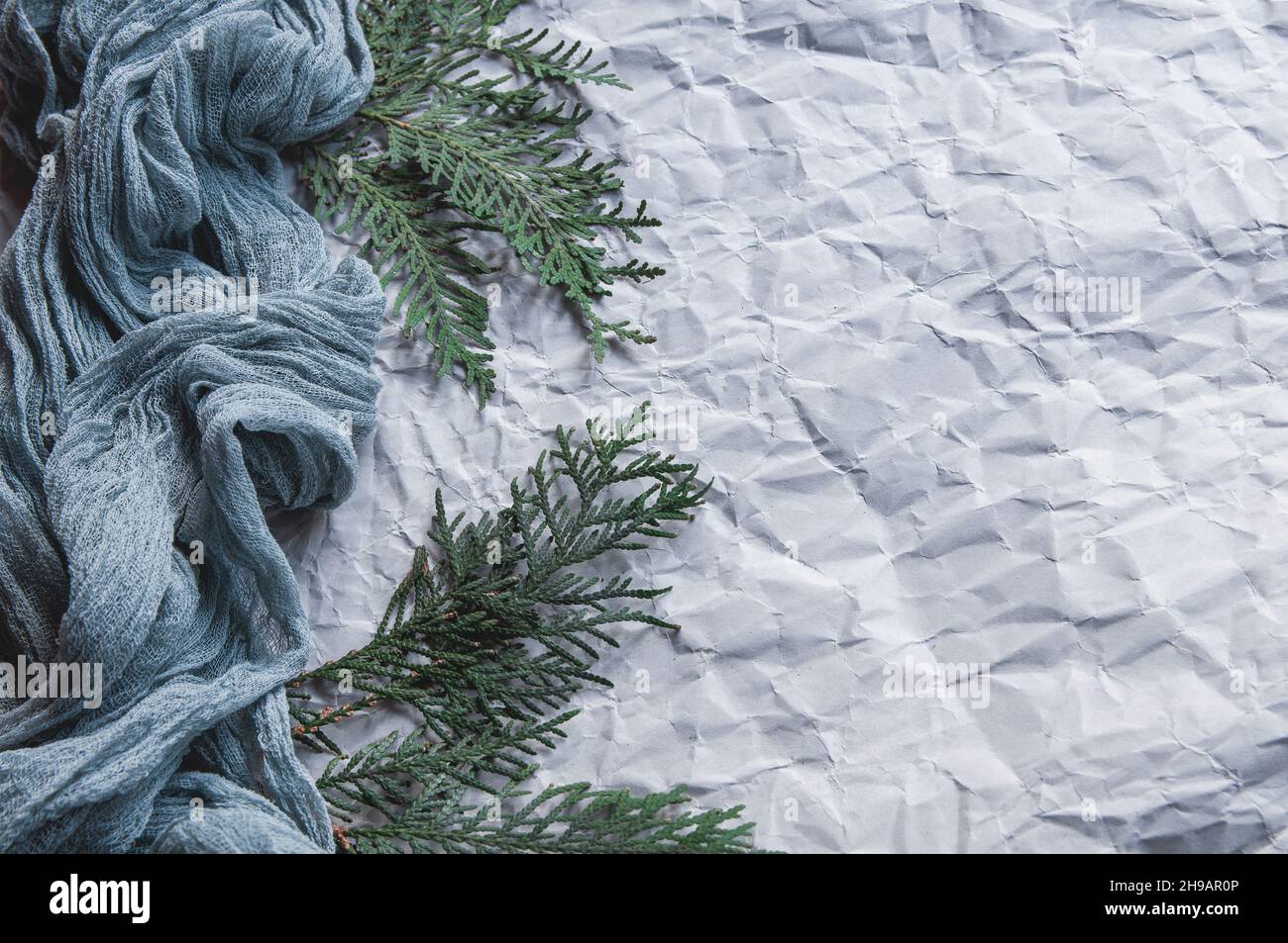 Tovaglie di garza su sfondo grigio con sprigs di abete, cursore di scorrimento a garza blu su sfondo leggermente sgualcito Foto Stock