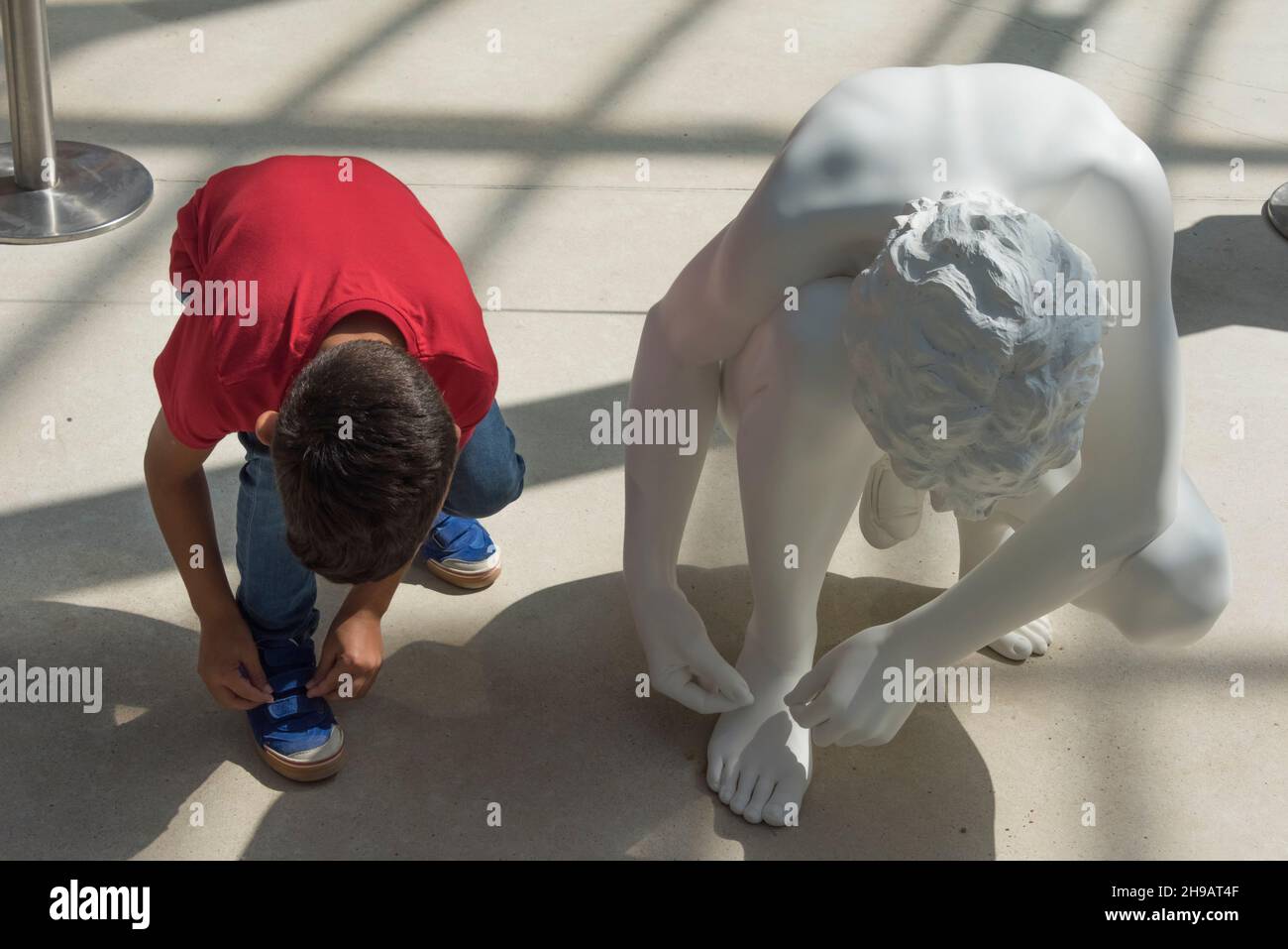 Ragazzo coping statua per legare merletti scarpe, Crystal Palace in Buen Retiro Park, Madrid, Spagna Foto Stock
