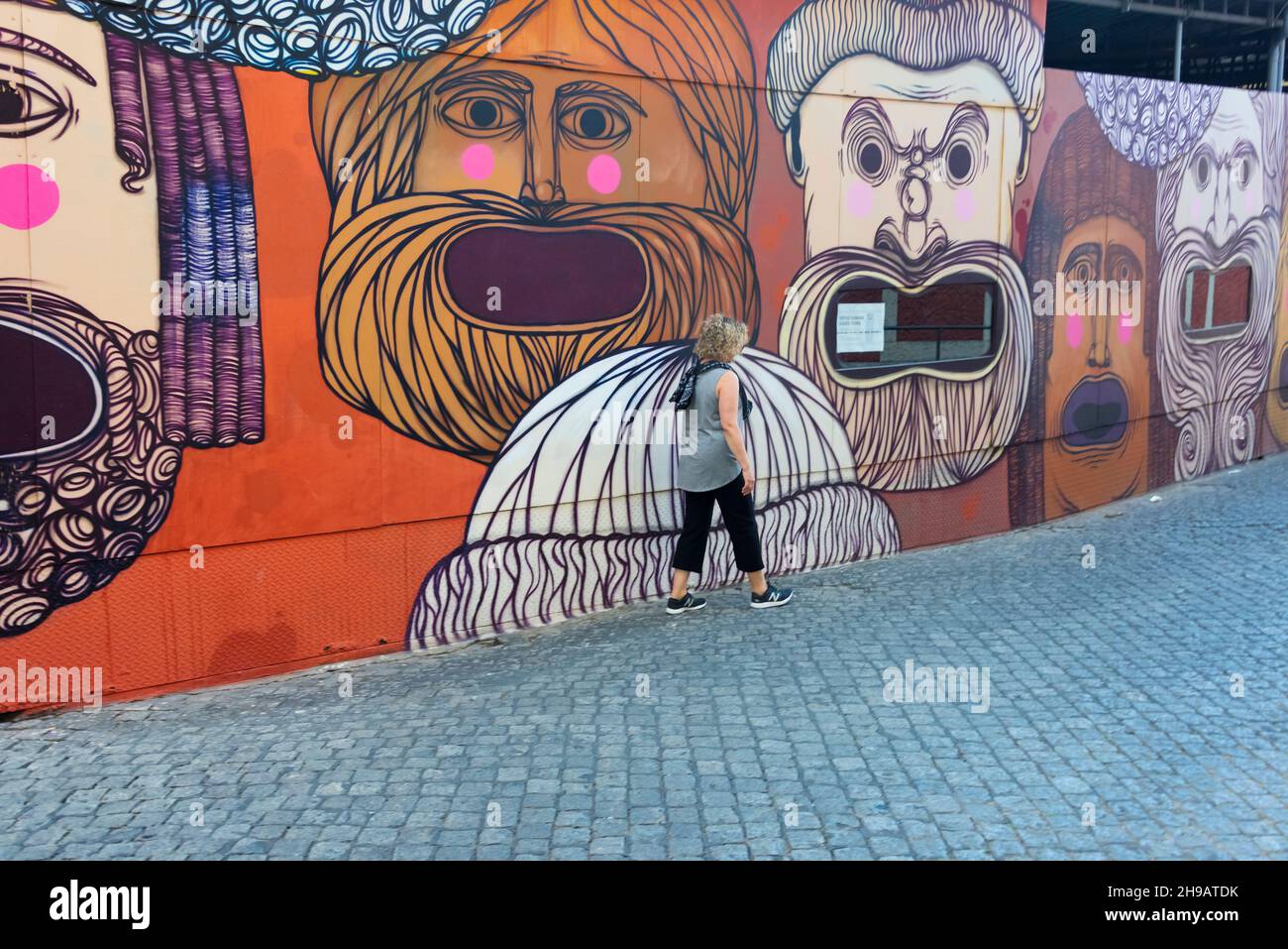 Murale sulle mura con strada lastricata ad Alfama, una delle zone più antiche di Lisbona, Lisbona, Portogallo Foto Stock