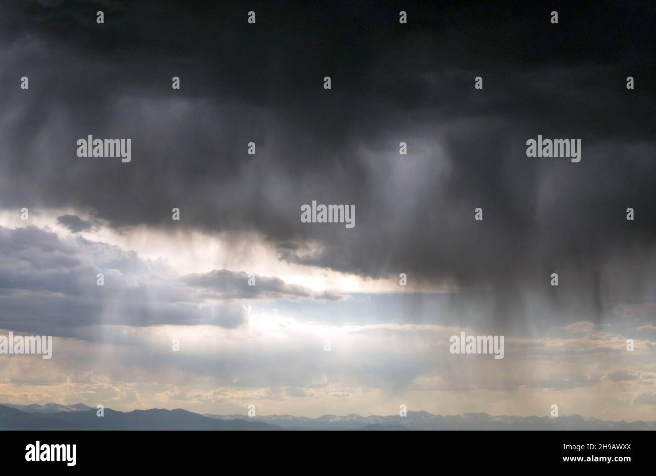 Le nuvole di pioggia si aprono sulle montagne rocciose in Colorado, inviando torrenti di acqua giù sulla terra Foto Stock