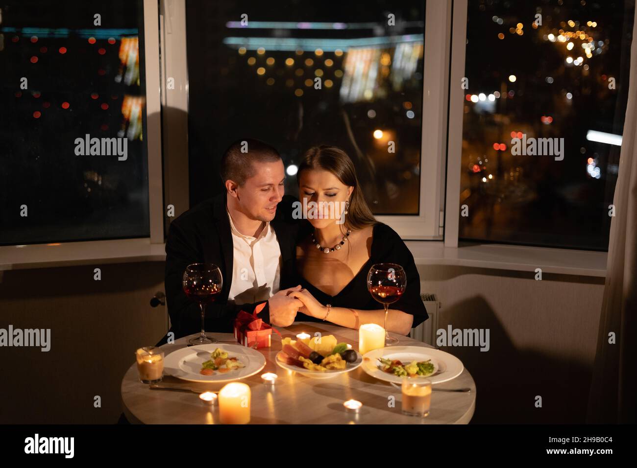 cena romantica per due con candele, appuntamento a lume di candela con vino, coppia innamorata il giorno di san valentino, relazione uomo e donna vacanza a casa Foto Stock