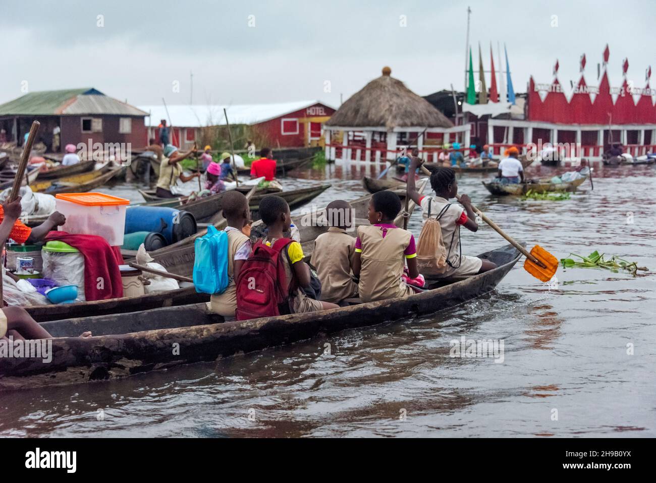 Gli studenti in uniforme vanno a scuola in barca sul lago Nokoue, Benin Foto Stock