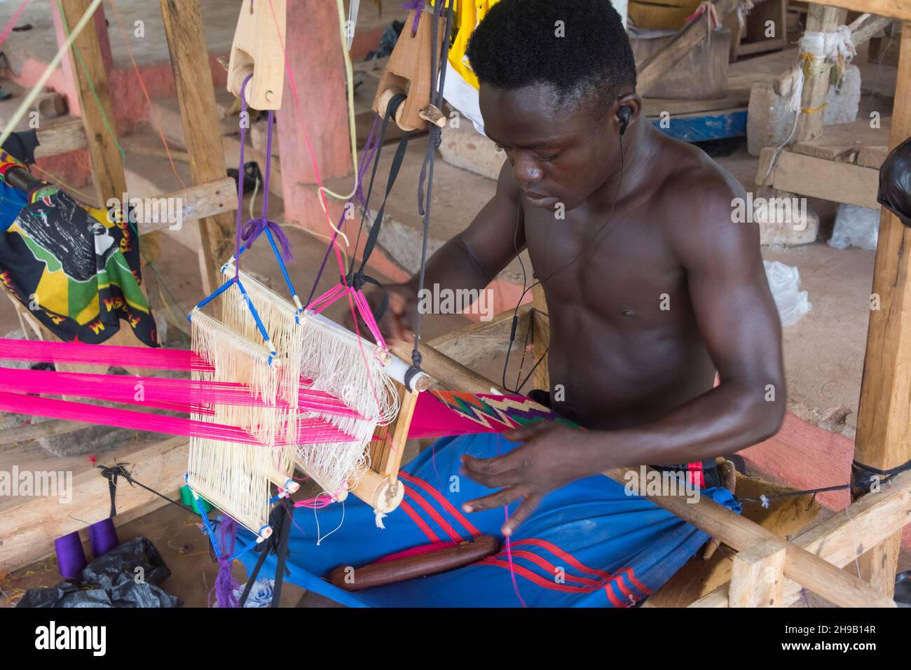 Uomo tessitura Kente tessuto, un tipo di seta e tessuto di cotone fatto di tessuto intertessuto strisce fatto e nativo del gruppo etnico Akan del Ghana, Ashanti R Foto Stock