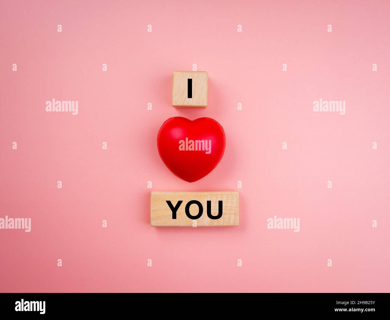 Ti amo, testo su blocco di cubo di legno e palloncino rosso cuore su sfondo rosa pastello. Stile minimal Love Concept. Foto Stock