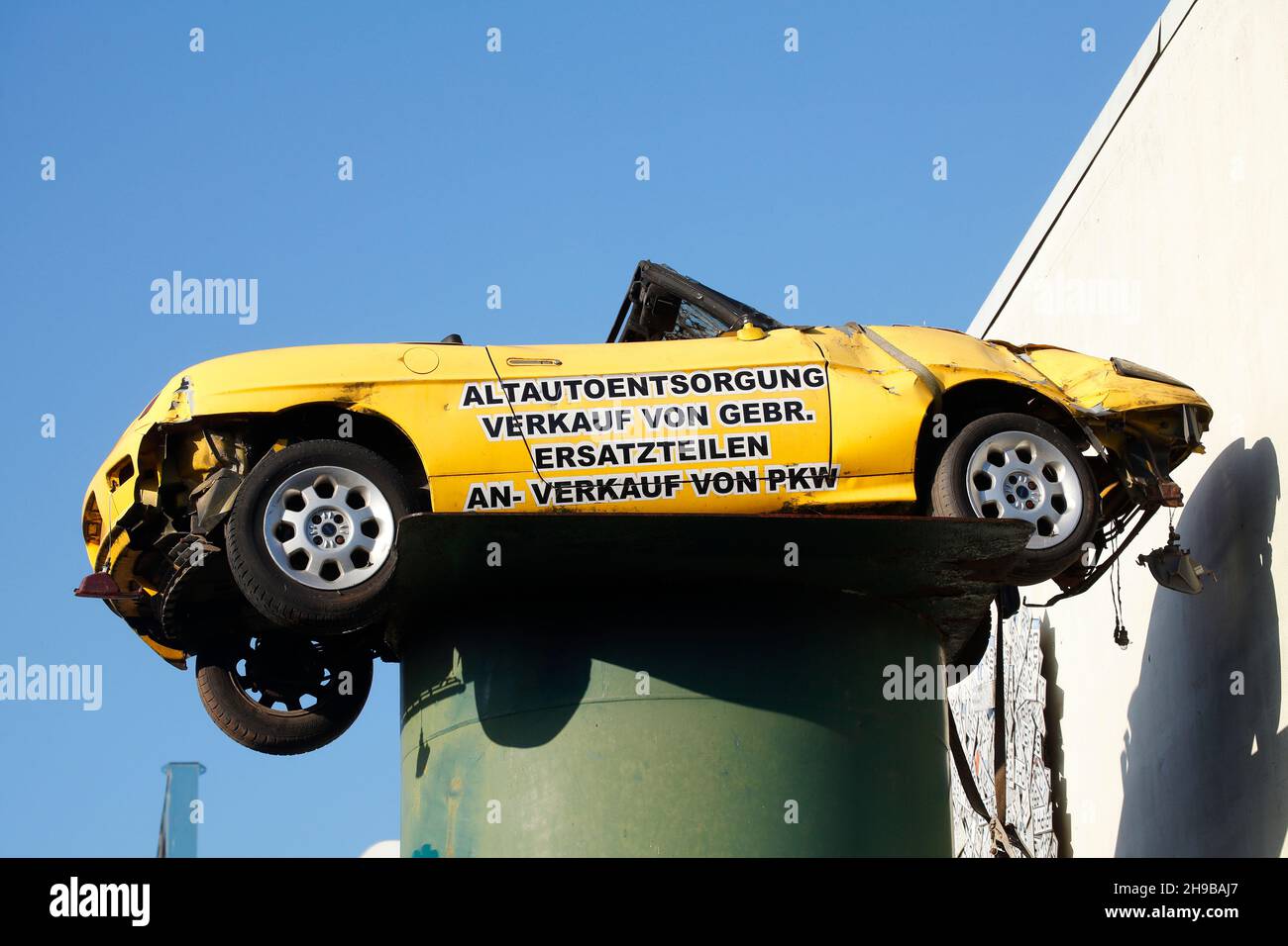 Cartello pubblicitario su un'auto distrutta in un cantiere. Germania, Europa Foto Stock
