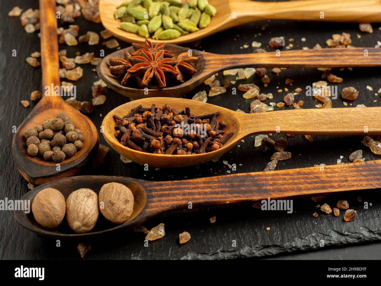 Selezione di spezie su tavola di legno scuro. Cibo o concetto di cottura speziato, mangiare sano sfondo. Foto Stock