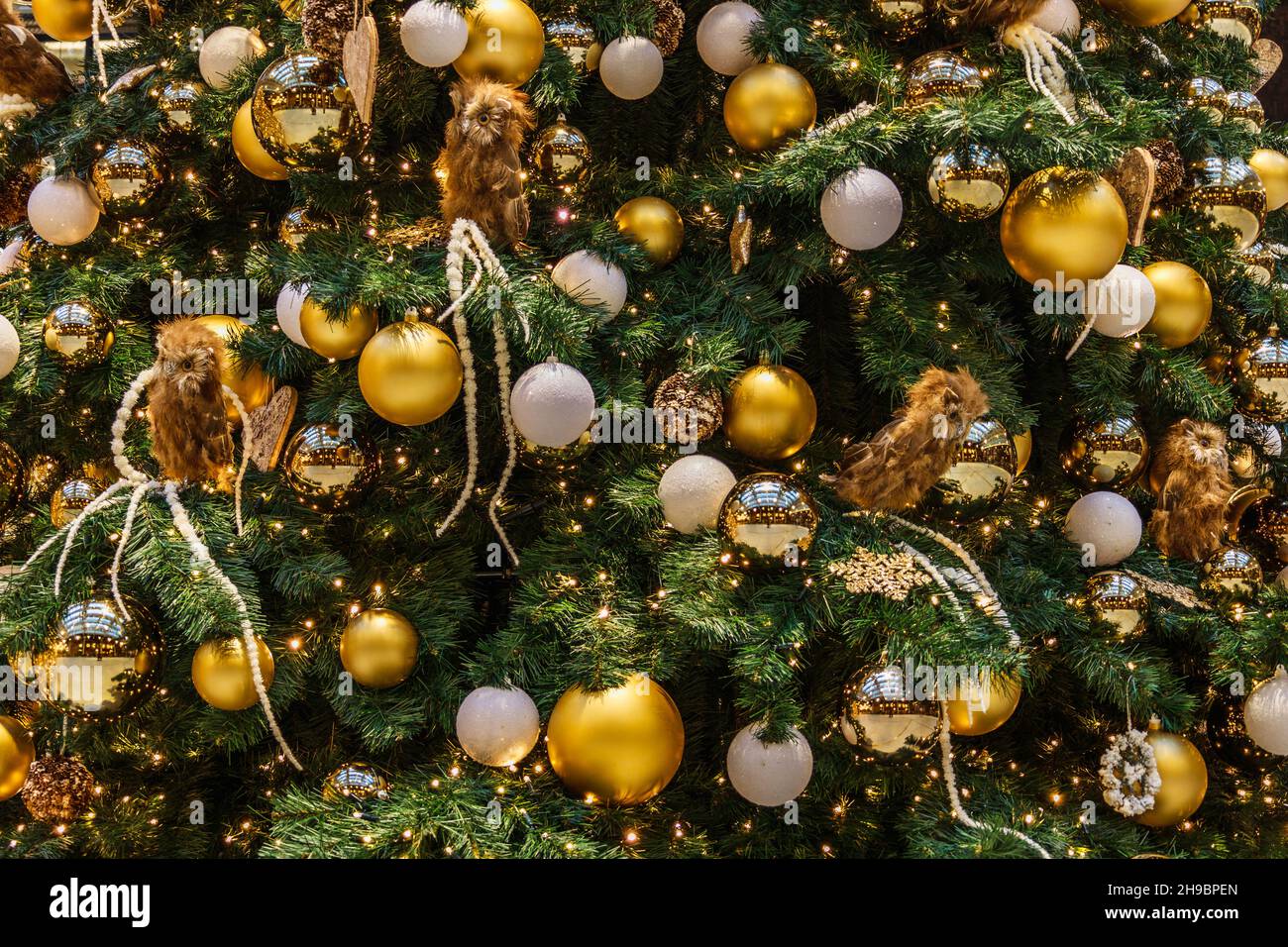 Grande albero di Natale decorato con palle, luci e giocattoli Foto Stock
