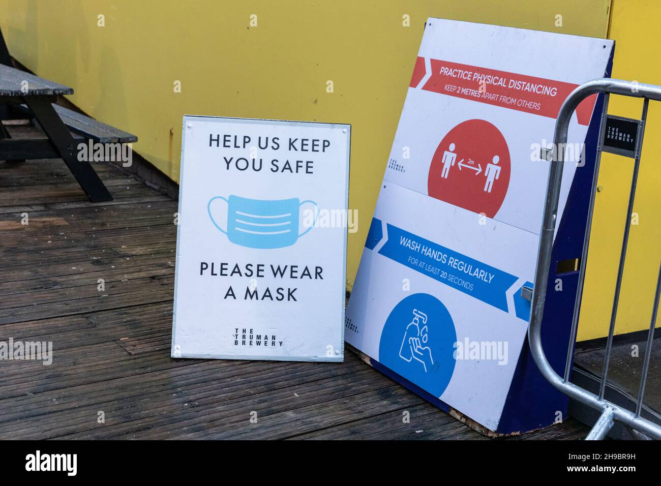 Londra, Regno Unito. 5 dicembre 2021. Un cartello al Backyard Market, al largo di Brick Lane, nella trendy Spitalfields di Londra, ricorda ai visitatori di indossare una maschera e mantenere la loro distanza con gli altri, come le coperture facciali e le distanze sociali fanno un ritorno in molte aree della vita pubblica, A causa dell'emergere della nuova variante Omnicron e dei numeri generalmente elevati, Credit: Imagplotter/Alamy Live News Foto Stock